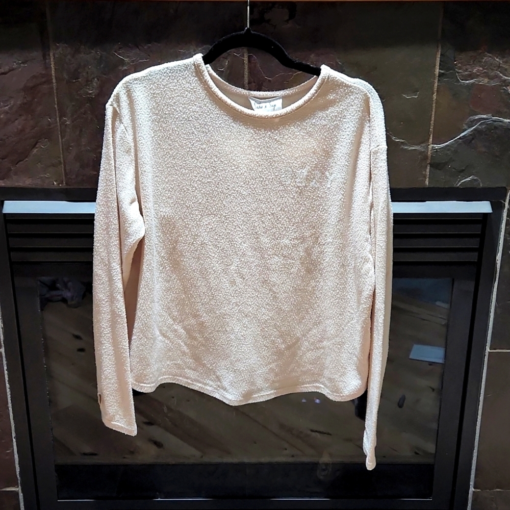 Fuzzy pink sweater with "Cozy" stitched on